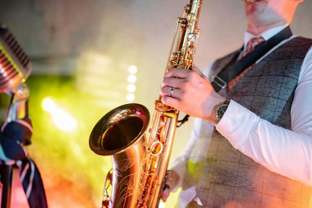 Ein Musiker, der mit Leidenschaft Saxophon spielt und sein Talent unter farbenfrohen Bühnenlichtern präsentiert.